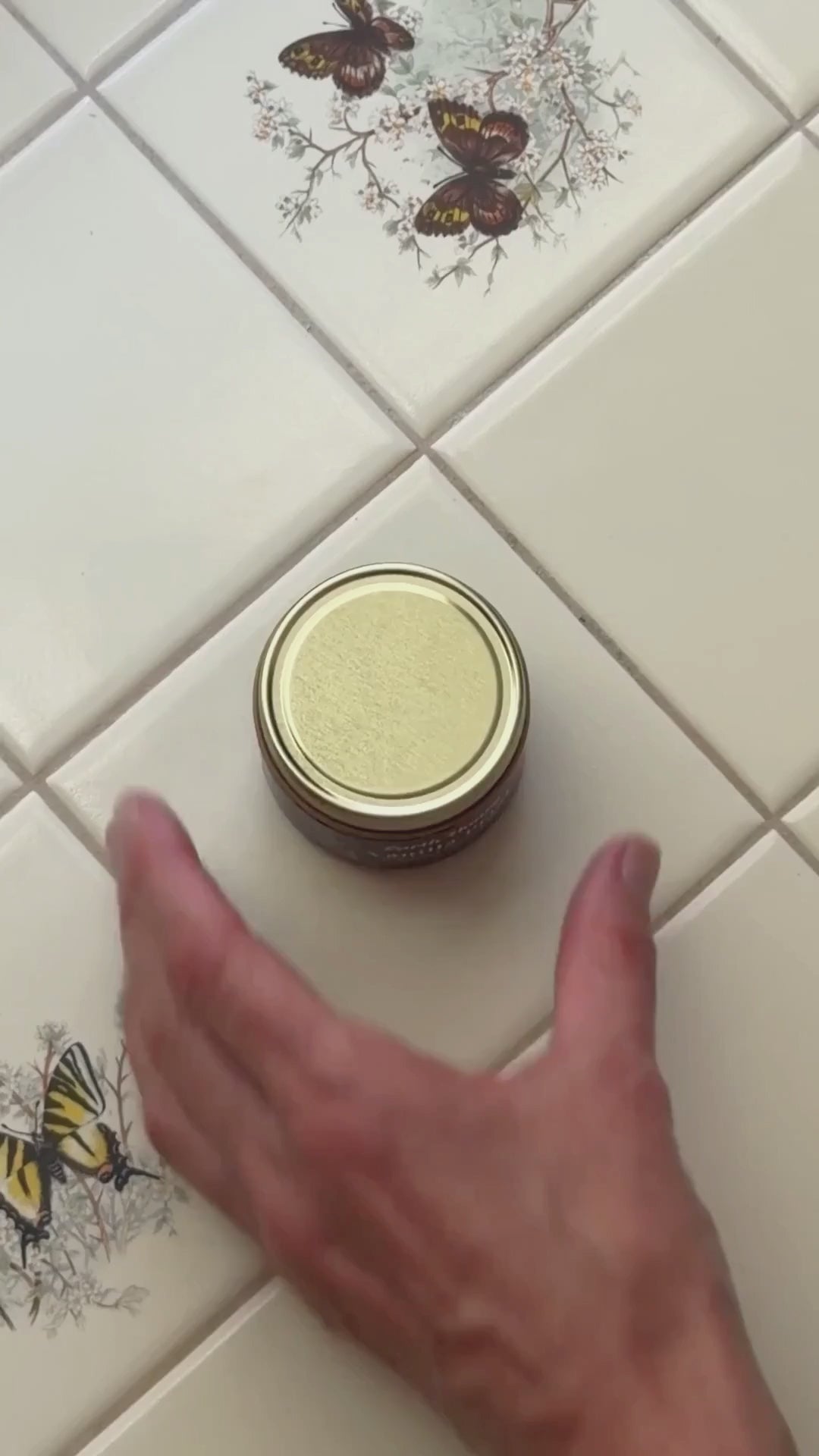 an overview shot of someone opening a jar of Vanilla Petal Tallow balm and rubbing it on their skin